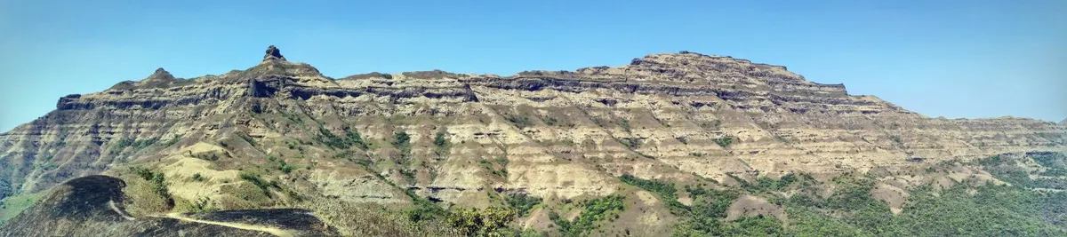A wide panoramic view from Torna Fort, with hills and sky.