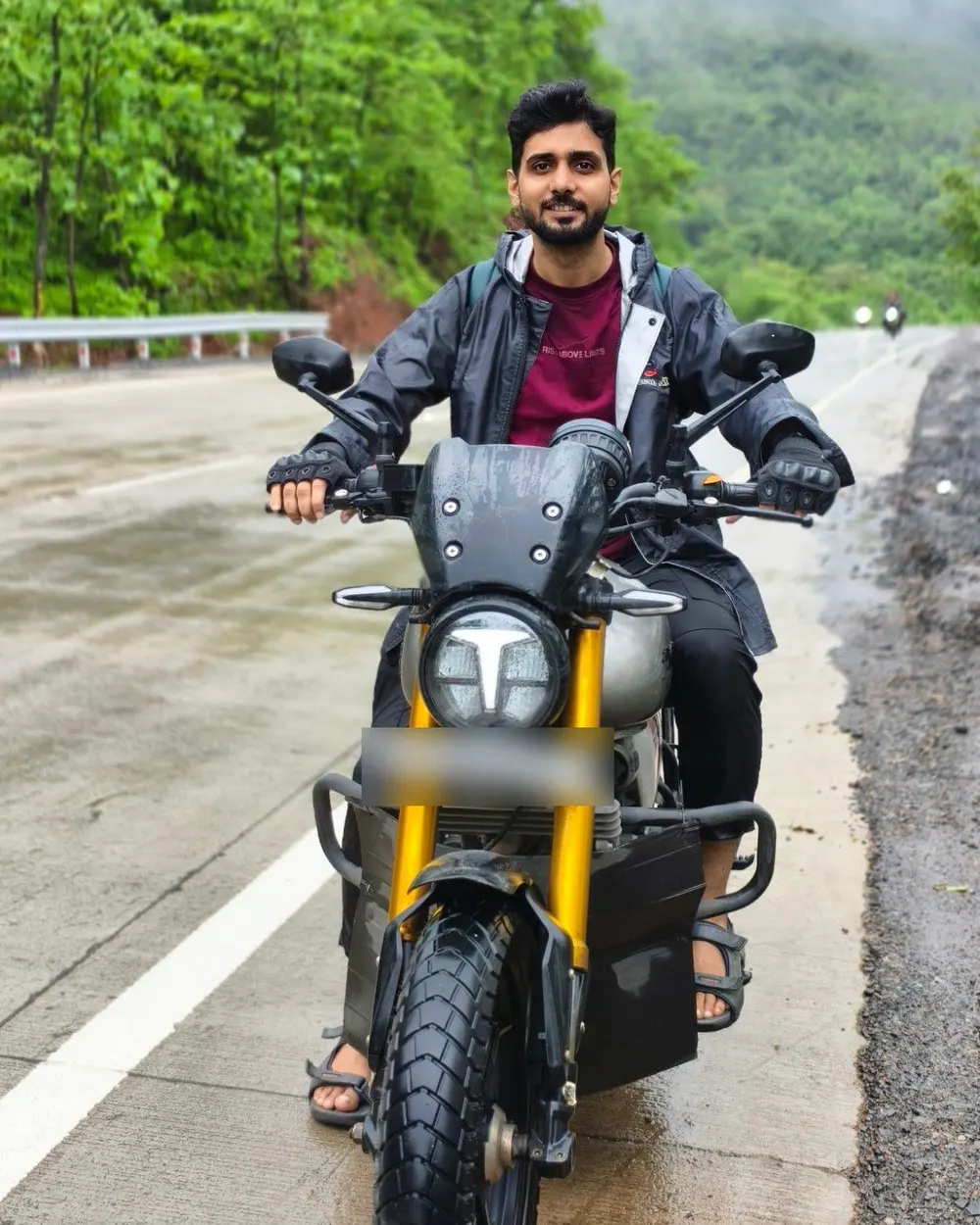 Me on Musafir, a grey and gold TVS Ronin, stopped on a wet ghat road under low cloud.